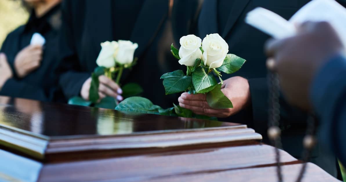 white roses over a casket | Oliver Law Firm